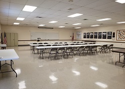 Large meeting room with long tables and many chairs