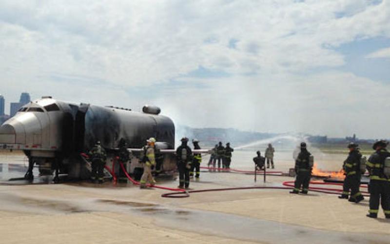 Firefighters extinguishing an aircraft fire on the tarmac.