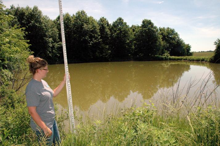NRCS district technician Cassie Lenzenhuber was part of the team that evaluated Matthew Spiers' pond for gravity-fed tanks. Photo by Linda Geist