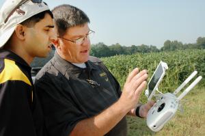 Kent Shannon, right, shows agronomy specialist Dhruba Dhakal how to use a drone to take aerial images of a soybean field in the Missouri Strip Trial Program.Photo by Linda Geist