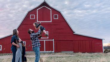 A family in front of a barn.