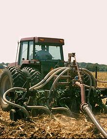 Man in a tractor treating a field.